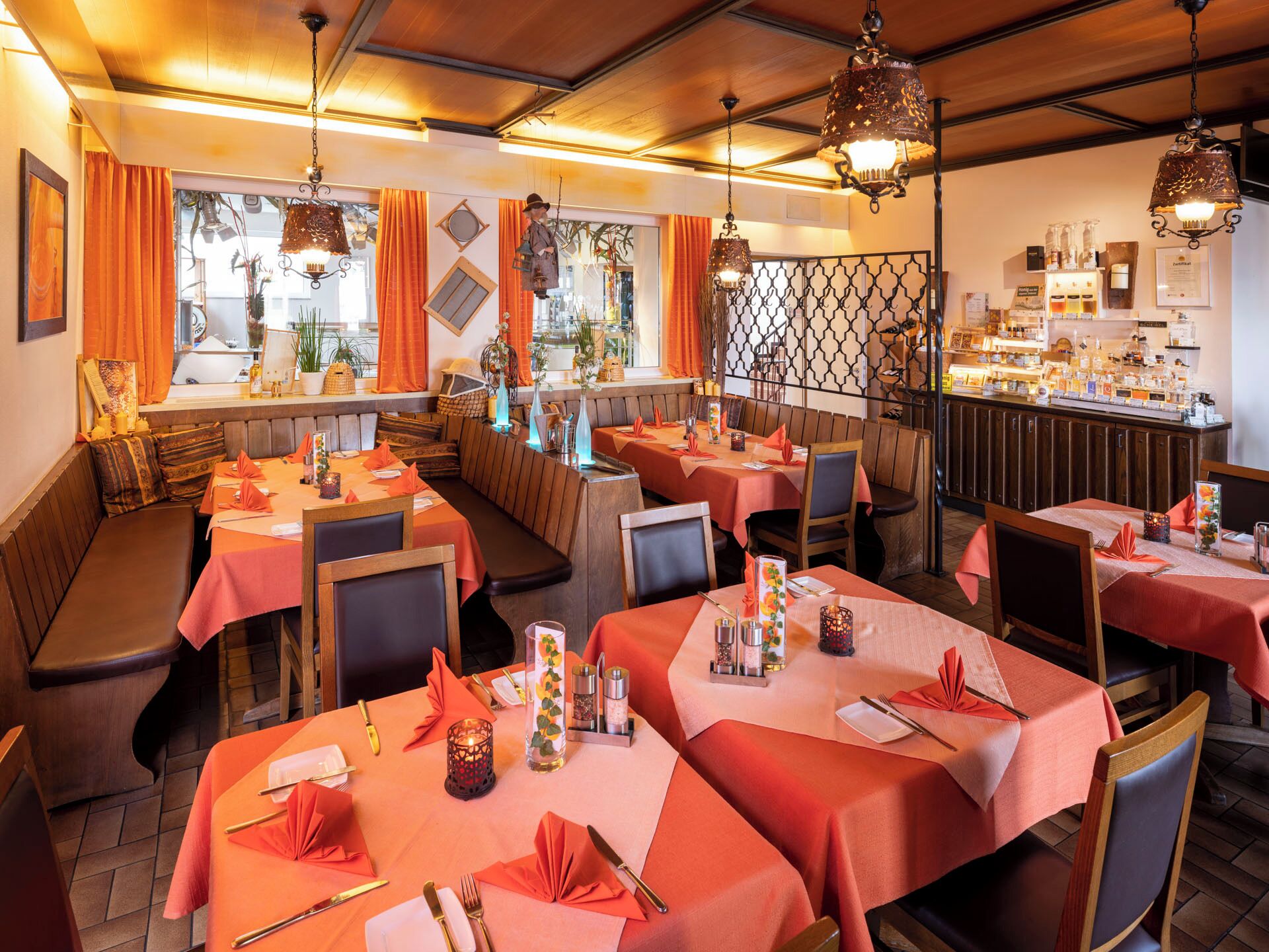 Un interior de restaurante con cabinas, mesas y lámparas colgantes.