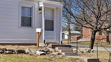A single-story house with a front door, a mailbox, and a small porch area.