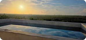 Piscina retangular com vista ampla da paisagem ao fundo.