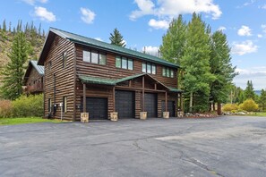 A log cabin with a garage and a covered porch. - Whispering River Ranch | Hot Tub + Riverfront (Breckenridge)