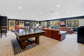 A spacious room with a ping pong table, leather sofas, and a large window. - Whispering River Ranch | Hot Tub + Riverfront (Breckenridge)