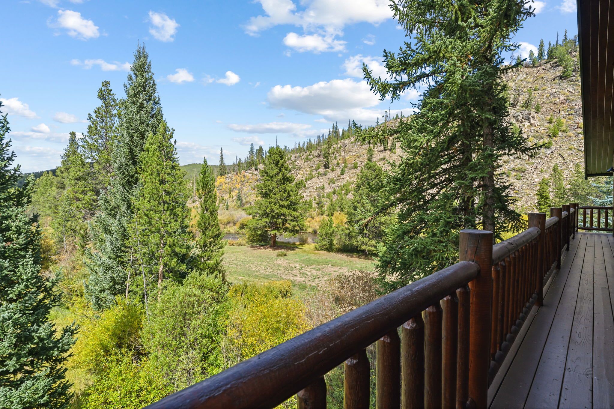A wooden deck with a view of a mountainous landscape.