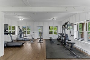 Une salle de sport équipée de tapis de course, de vélos d’appartement et d’appareils de musculation.
