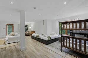 Une chambre moderne avec un grand lit, un canapé et un lit superposé.