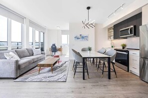 Ein modernes Wohnzimmer mit Sofa, Couchtisch und Essbereich.
