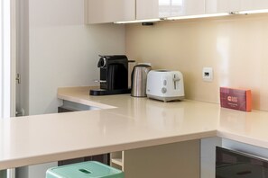 Una kitchenette equipada con cafetera, tostadora y un cartel que dice 'GUEST READY'.