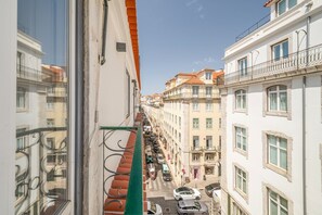 A narrow street with buildings on both sides, featuring balconies and a clear sky. - GuestReady - Wonderful flat near the Pink Street (Lisbon)