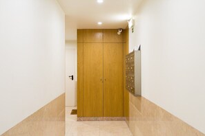 A hallway with a wooden wardrobe, a mail slot, and a wall-mounted mail slot. - GuestReady - Stylish stay near the National Museum (Lisbon)