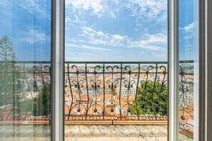 A balcony with a wrought iron railing overlooking a cityscape with red-roofed buildings. - GuestReady - Fantastic flat near S. Jorge Castle (Lisbon)