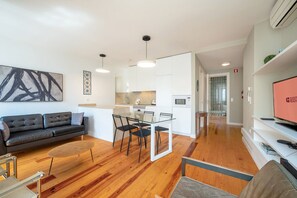 Ein modernes Apartment mit Wohnzimmer, Essbereich und Küchenzeile.