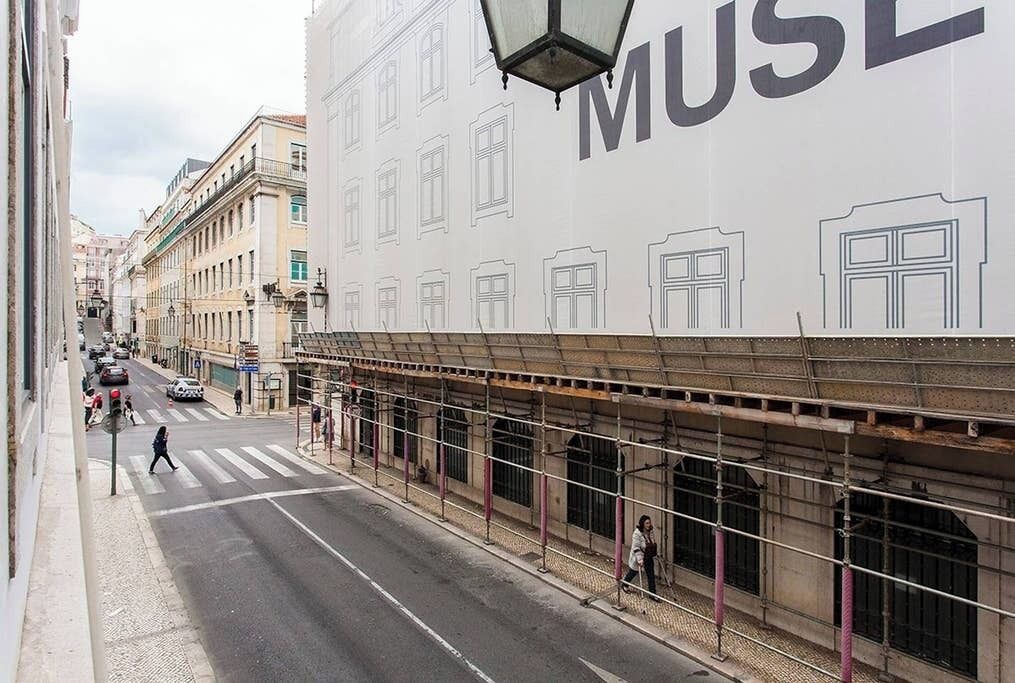 A street view with a large building facade featuring a prominent 'MUSE' sign.