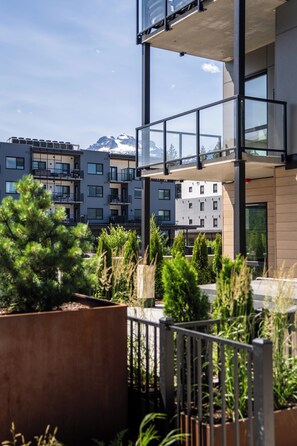 A modern multi-story building with balconies and a view of snow-capped mountains. - Jalapeño Junction Cabin - 1300 sqft Townhome with Private Hot tub (Revelstoke)