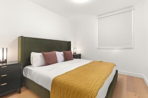 A bedroom with a bed, bedside tables, and a window. - Jalapeño Junction Cabin - 1300 sqft Townhome with Private Hot tub (Revelstoke)