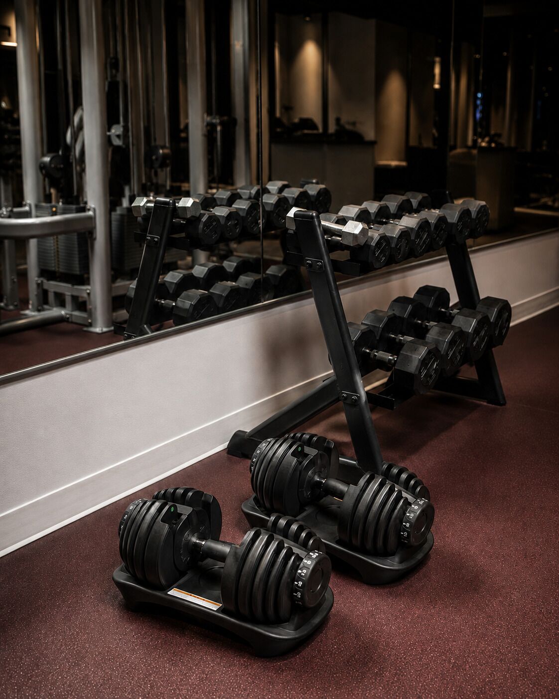 Une salle de sport équipée de matériel de musculation, notamment des haltères et un banc.