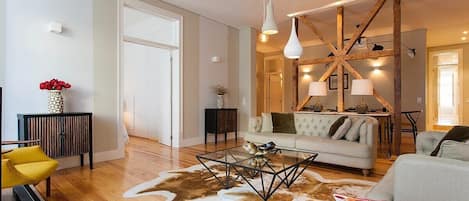 Un salon moderne avec un canapé, une table basse et une structure décorative au plafond.