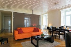 A modern living room with a sofa, coffee table, and dining area. - GuestReady - Sleek escape near Santa Justa Lift (Lisbon)