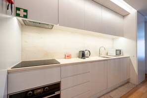 Een moderne keuken met een inbouwoven, een koffiezetapparaat en een magnetron.