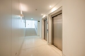 A corridor with a staircase leading to an elevator. - GuestReady - Cosy stay near Money Museum (Lisbon)