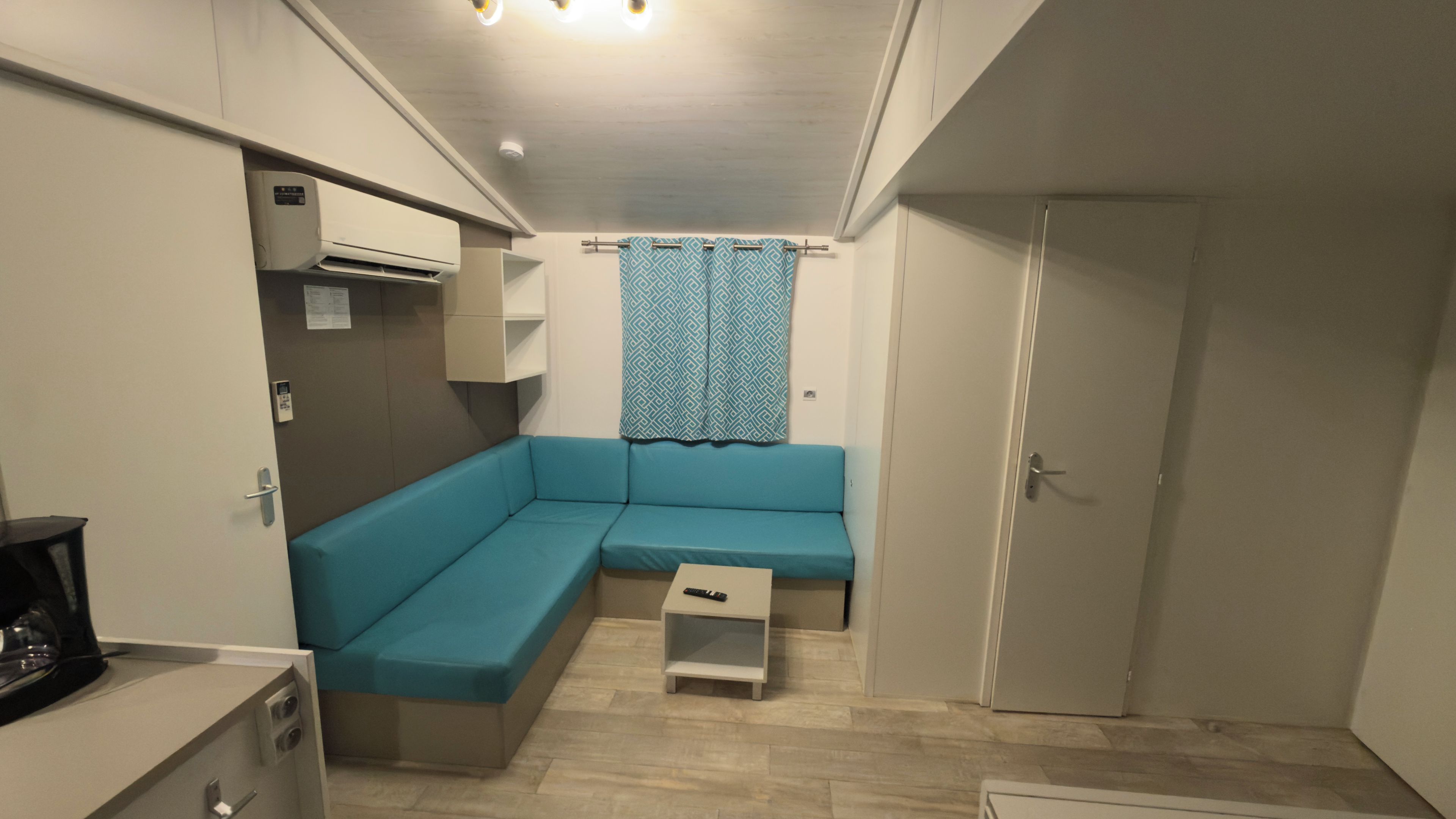 Un espace de vie compact comprenant un canapé, une petite table et une porte.