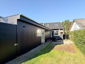 A residential property with a paved patio, a black exterior wall, and a small garden area. - 4 Star Holiday Home in Skanderborg (Skanderborg)