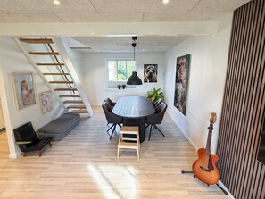 A modern interior with a dining area, a staircase, and a guitar. - 4 Star Holiday Home in Skanderborg (Skanderborg)