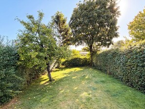 A well-maintained garden with a variety of trees and a neatly trimmed hedge. - 4 Star Holiday Home in Skanderborg (Skanderborg)