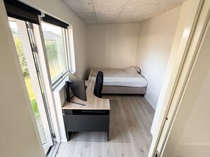 A compact room with a bed, a desk with a chair, and a window. - 4 Star Holiday Home in Skanderborg (Skanderborg)