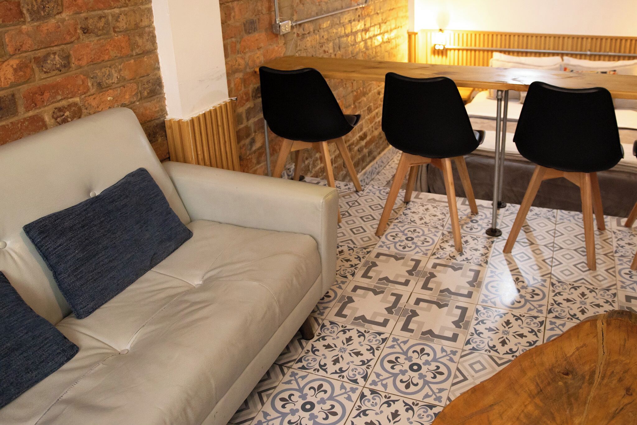 Habitació amb sofà, dues cadires, taula i terres amb rajoles decorades.