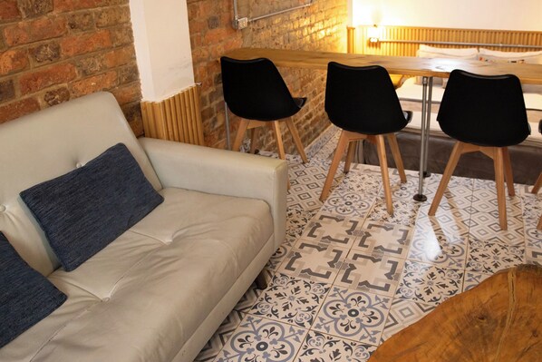 Una stanza con un divano, due poltrone, un tavolo e piastrelle decorative.