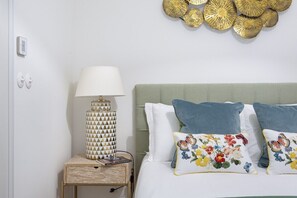 Ein Schlafzimmer mit einem Bett, einer Nachttischlampe und Wanddekoration.
