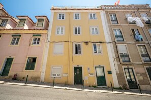 Una filera d'edificis d'alguns pisos amb balcons, portes i finestres.