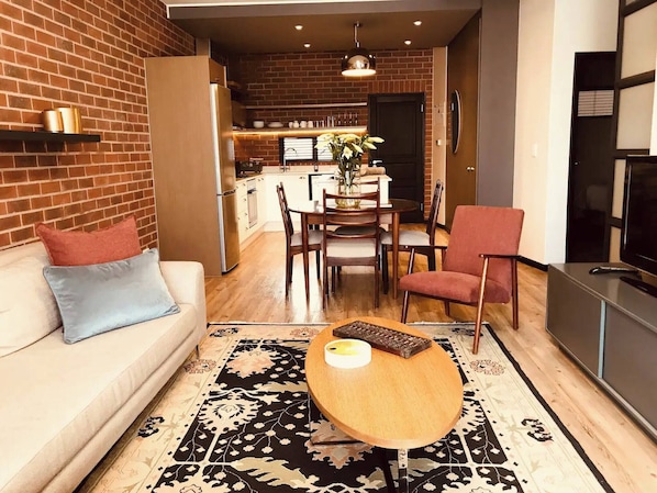 A modern living room with a sofa, a coffee table, and a red armchair.