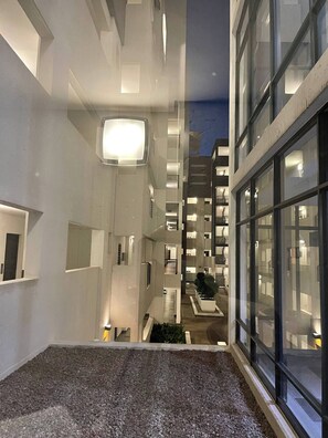 A modern building with a central atrium, multiple floors, and a view of the surrounding area.