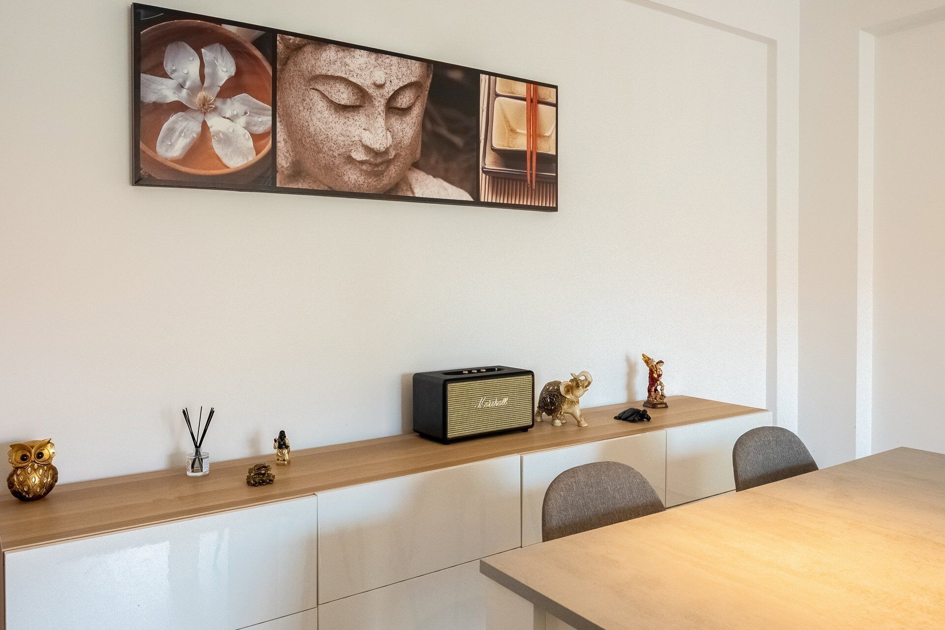 A dining area with a table, chairs, a cabinet, and a radio.
