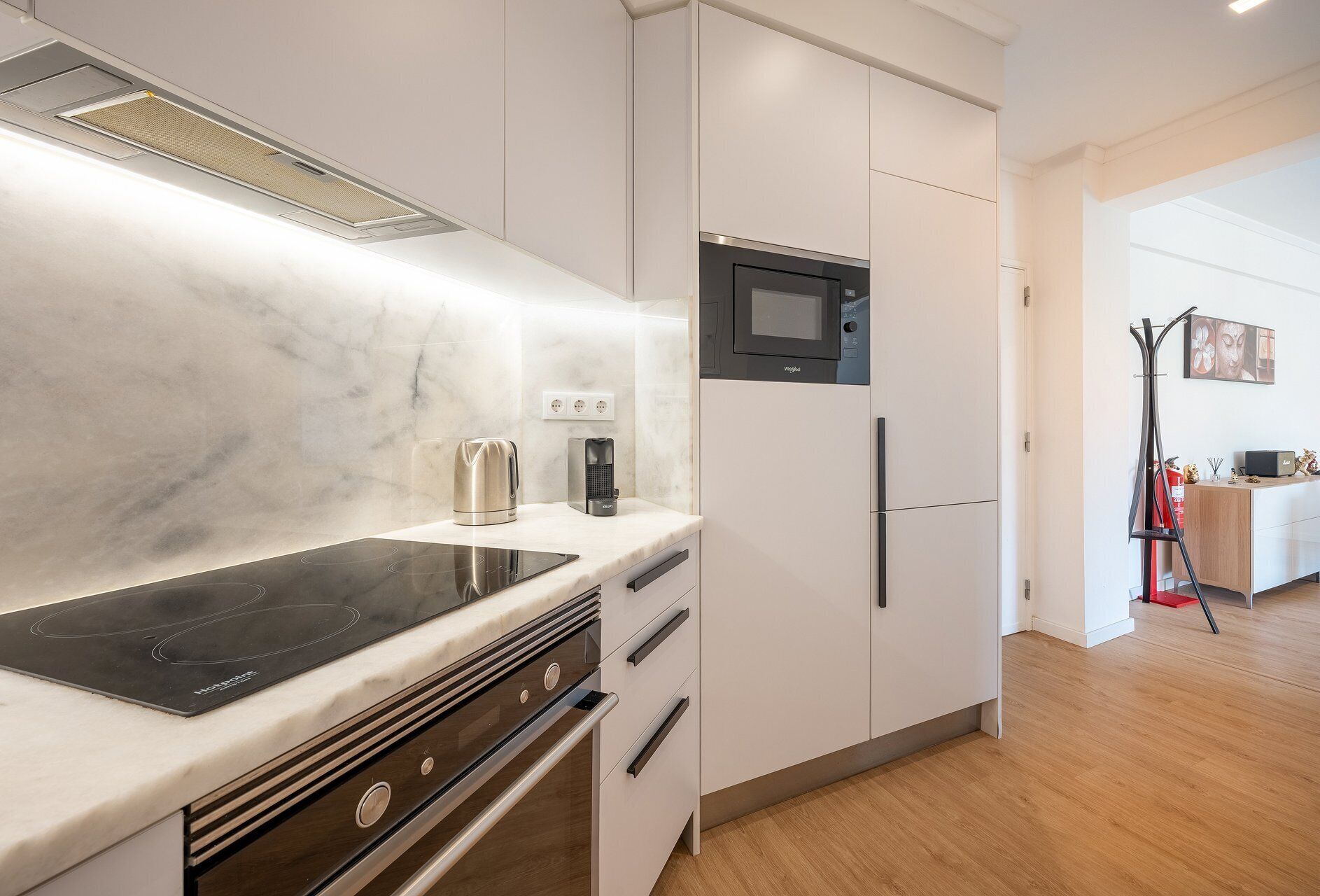 Una cocina moderna con placa de inducción integrada, microondas y refrigerador.