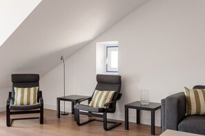 A modern room with two armchairs, a small table, and a floor lamp. - GuestReady - Gorgeous apt with river view (Lisbon)