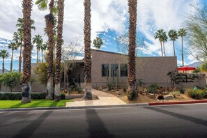 A modern building with a flat roof, surrounded by palm trees and a well-maintained garden. - Noline Hideaway by GPM - Chic 2BR Condo Ironwood CC, Palm Desert (Palm Desert)