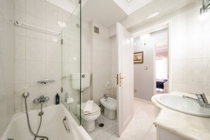 Ein modernes Badezimmer mit einer begehbaren Glasdusche, einer Badewanne, einer Toilette und einem Waschbecken.