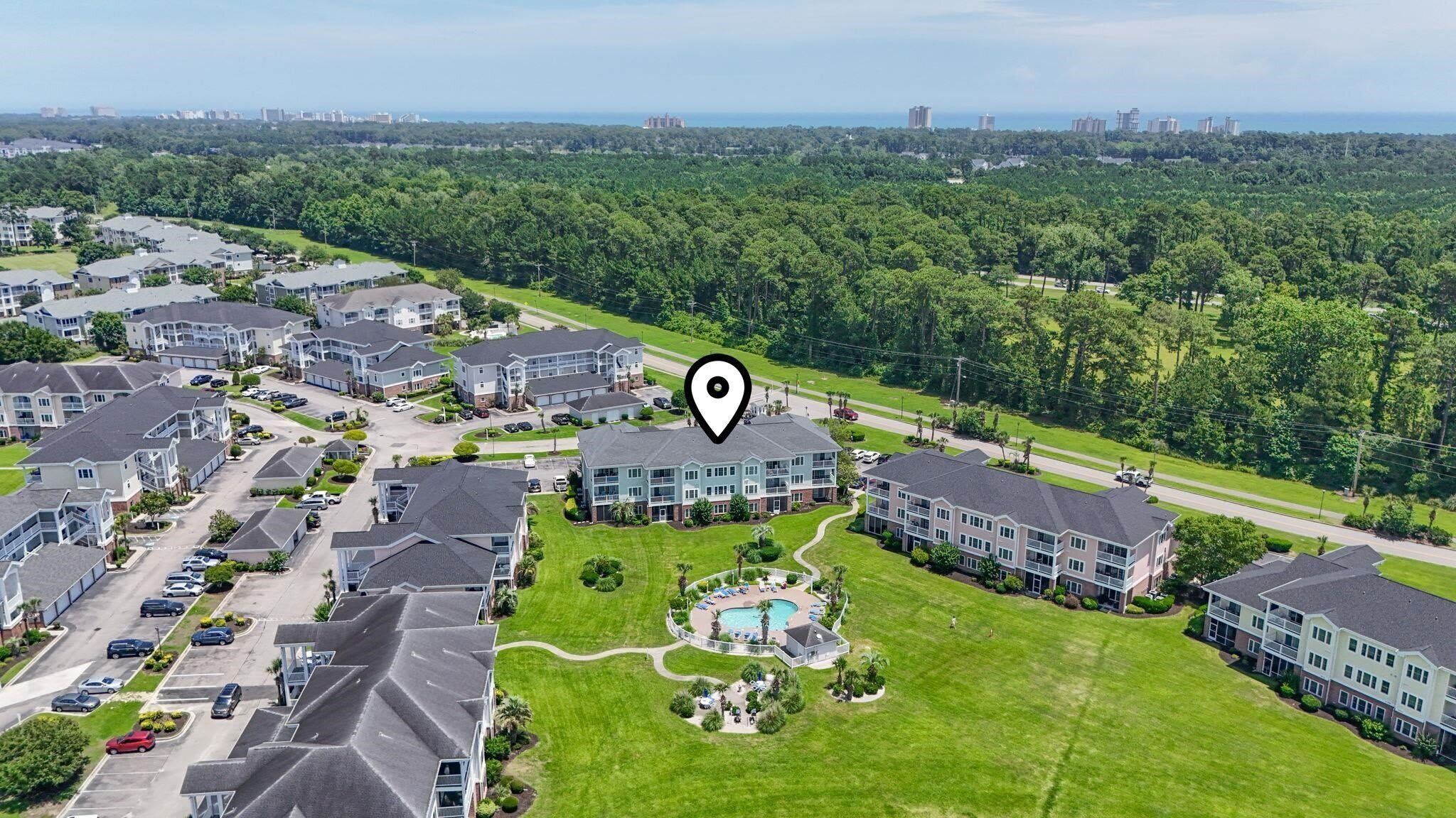 A residential area with apartment buildings, a swimming pool, and a park.