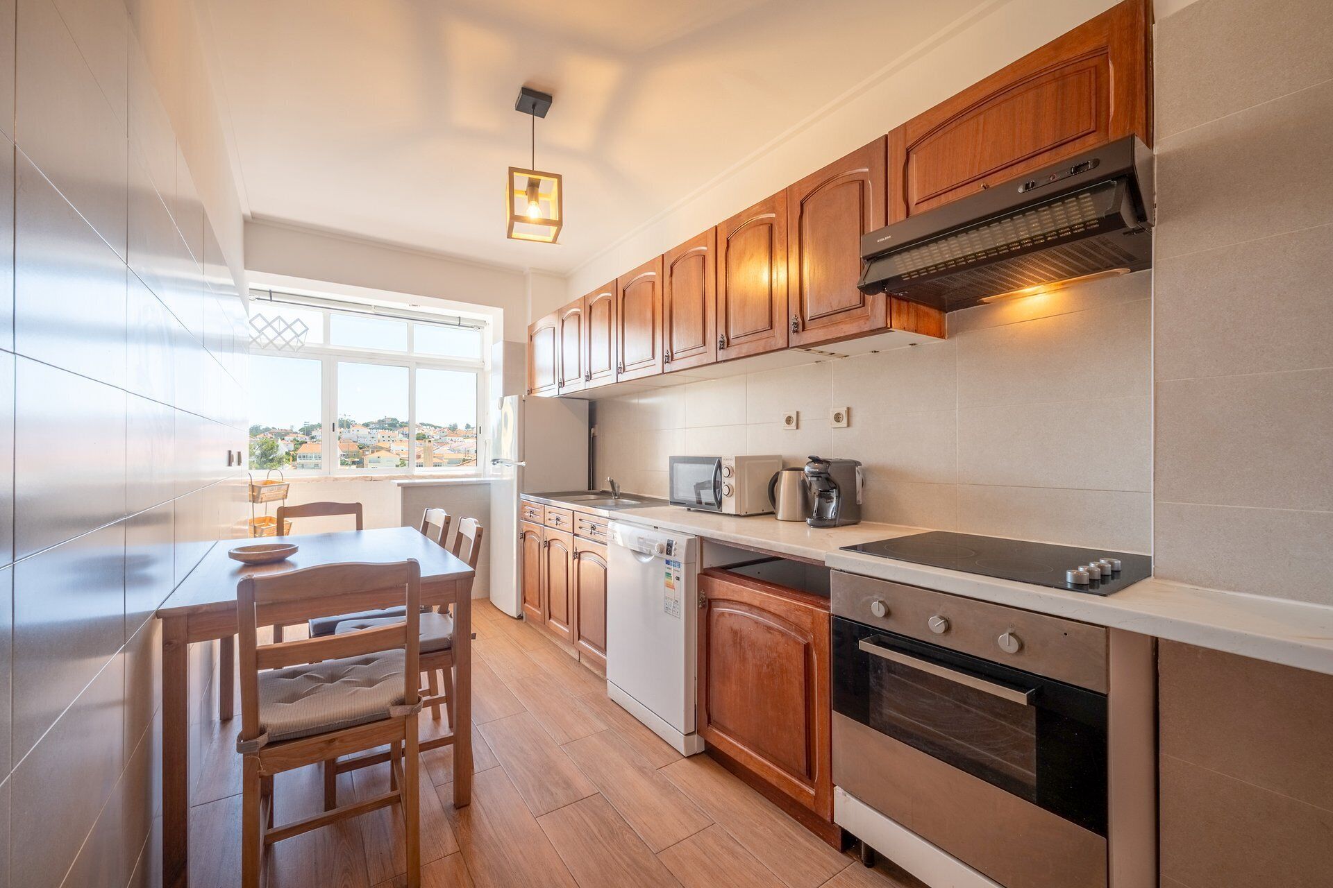 Een moderne keuken met houten kasten, een ingebouwde oven, een magnetron en een vaatwasser.