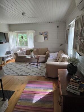 A cozy living room with a sofa, coffee table, and a bookshelf.