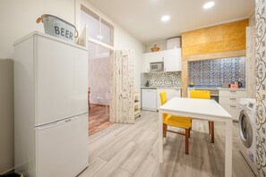 A compact kitchen with a refrigerator, microwave, and washing machine. - GuestReady - Stay in the Heart of Lisbon (Lisbon)