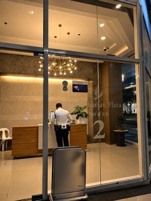 A modern reception area with a receptionist, a CCTV sign, and a sign for Manhatten Plaza Tower 2. - Le Petit Manhattan - 34th Floor Skyline Studio in Araneta City, Cubao (Quezon City)