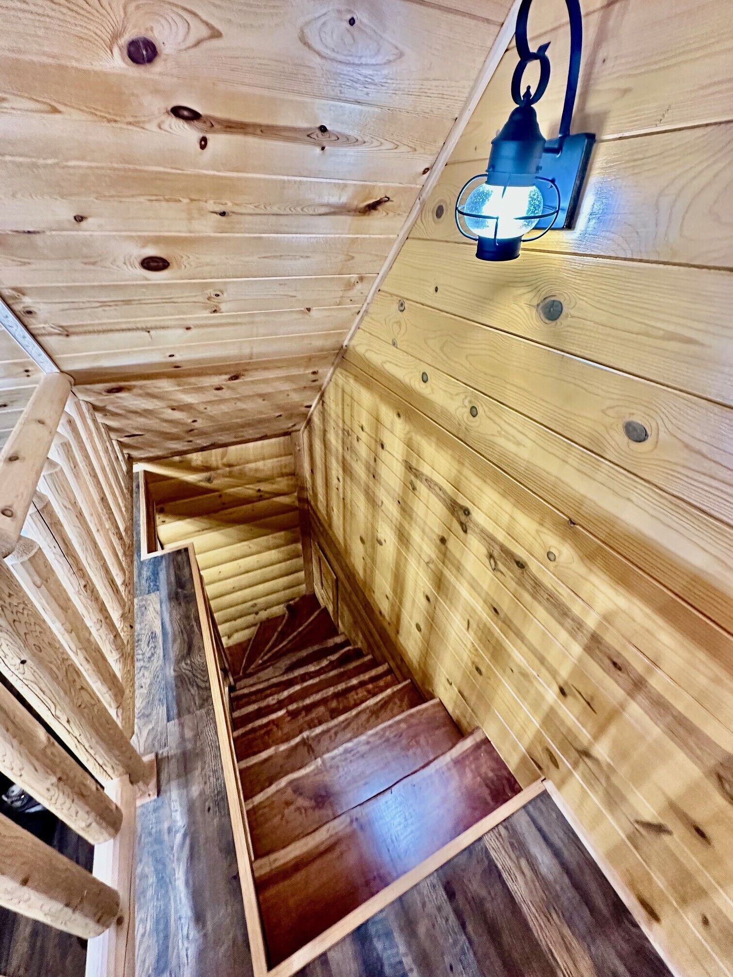 A wooden interior with a spiral staircase leading to a lower level.