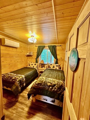 A cabin with two beds, a ceiling fan, a window with curtains, and a wall-mounted lamp. - A Custom-Built Swiss-Style Luxury Mountain Retreat - Entire 5 BR Chalet (Mount Jackson)