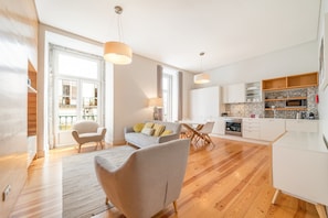 Un appartement moderne comprenant un coin repas, une cuisine et un salon avec un canapé et des fauteuils.