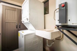 A laundry room with a washing machine, a dryer, and a water heater.