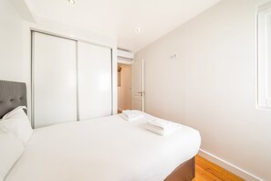 Ein Schlafzimmer mit einem Bett, einem Kleiderschrank und einer Tür zu einem Badezimmer.