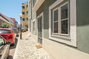 A narrow cobblestone street lined with parked cars and buildings. - GuestReady - Bold escape near Jardim da Estrela (Lisbon)