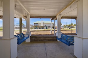 A covered outdoor area with two blue benches and a concrete floor. - Seascape St. George Island (Saint George Island)